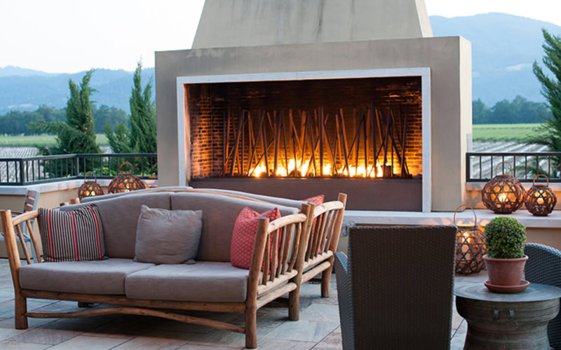 Outdoor fireplace with cozy seating area at Round Pond Estate. Perfect for relaxing evenings with scenic mountain views.