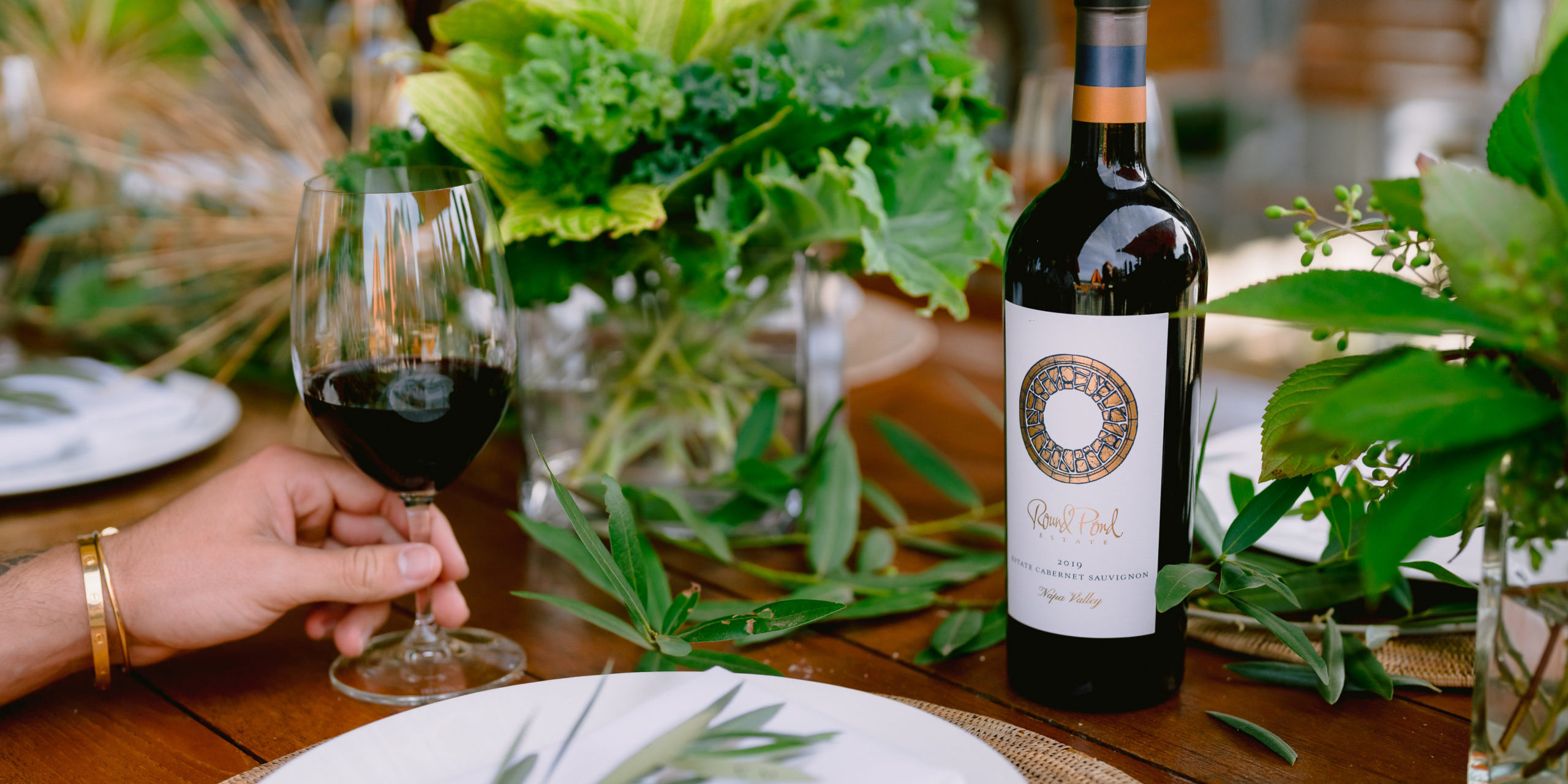Round Pond Holiday Table Poured glass of Round Pond Estate Cabernet Sauvignon and bottle on a set table.