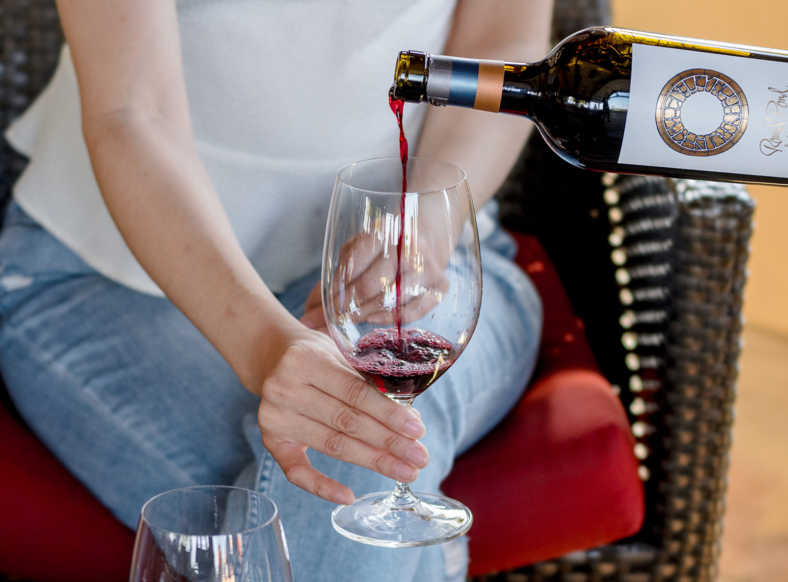 Pouring red wine into a glass at Round Pond Estate.