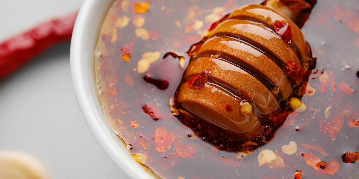 Bowl of hot honey on table, closeup