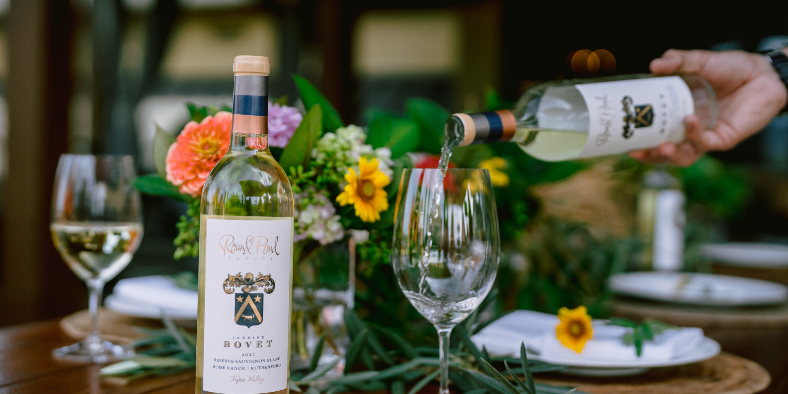 Jannine Bovet Sauvignon Blanc on the table and being poured into a wine glass