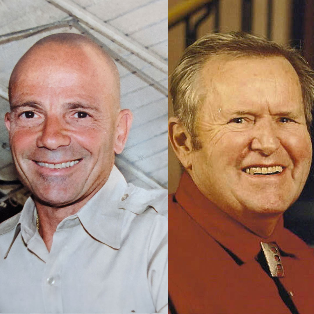 Two men smiling, one with a shaved head and the other with gray hair.