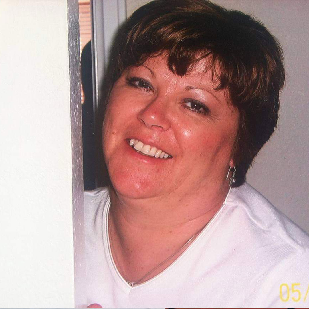 Elegant woman with short brown hair smiling at the camera.