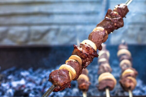 Delicious grilled meat and vegetable skewers cooking over an open flame, perfect for BBQ gatherings.