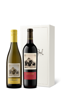 Bottle of Chardonnay next to a bottle of Cabernet Sauvignon in front of a cream gift box