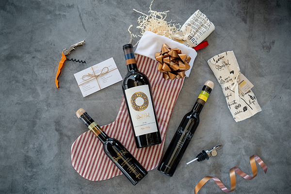 Elegant Napa Valley wine gift set with three bottles, wrapping paper, ribbon, and a corkscrew for special occasions.