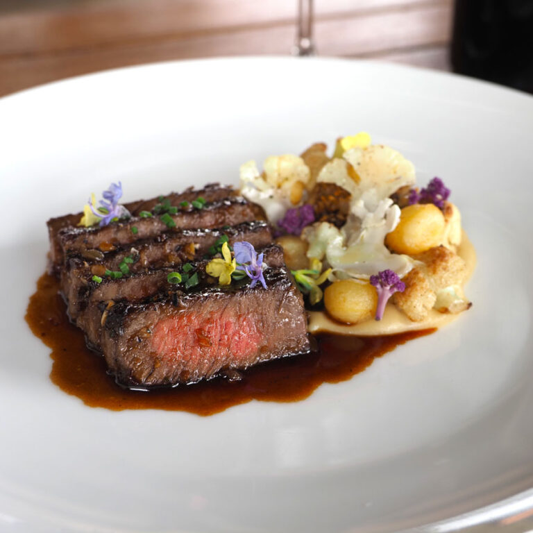 Roasted Ribeye A sliced ribeye on a plate with juices.