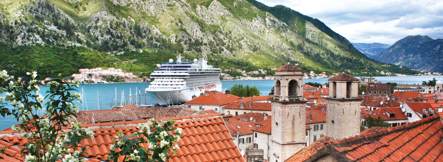 Beautiful view of the harbor with a cruise ship, historic buildings, and surrounding mountains at Round Pond Estate.