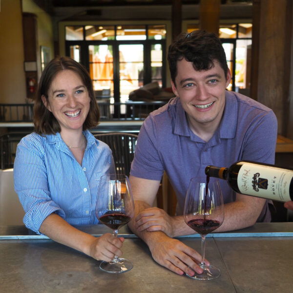Smiling guests enjoying Round Pond Estate’s Quick Round Experience in Napa Valley — a relaxed, under-$50 bar tasting featuring estate-grown wines, perfect for those seeking a casual and approachable wine tasting in Napa without sacrificing quality or hospitality.