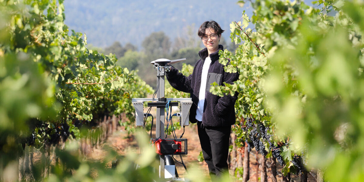 Agricultural robotics in Napa Valley vineyards — Budbreak founder Jonathan Moon stands with Emma, an AI vineyard robot at Round Pond Estate, showcasing sustainable winegrowing technology.