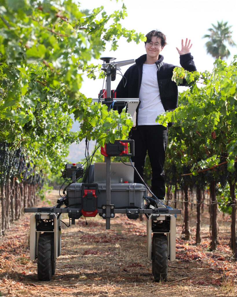 Agricultural robotics in Napa Valley vineyards — Budbreak founder Jonathan Moon stands with Emma, an AI vineyard robot at Round Pond Estate, showcasing sustainable winegrowing technology.