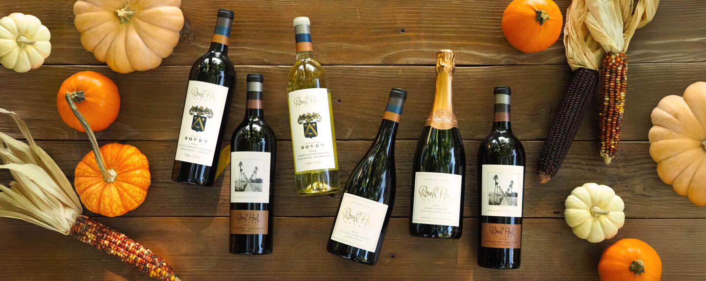 Elegant display of six wine bottles from Round Pond Estate surrounded by pumpkins and fall harvest decorations.