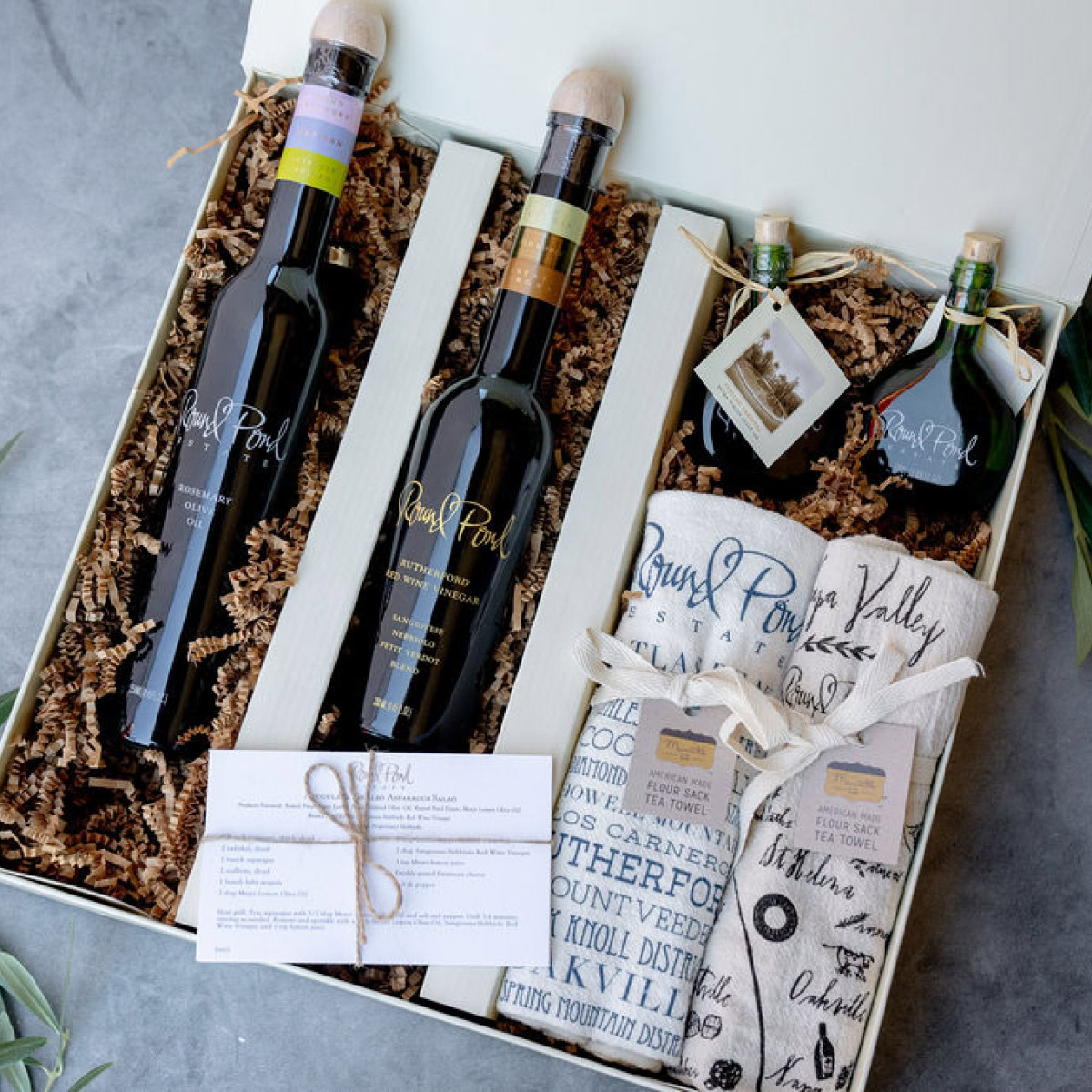 Elegant wine gift box featuring two bottles, a towel, and a note card, perfect for special occasions.