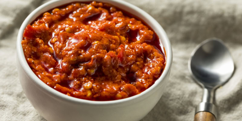 Delicious roasted red pepper and caper tapenade served in a white bowl, perfect for appetizers or spreads.