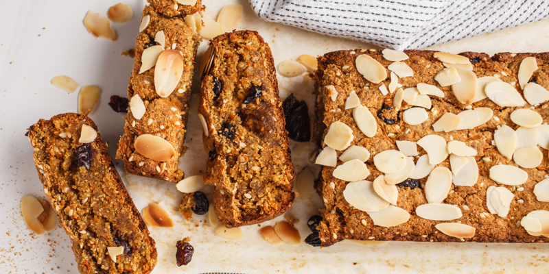 Delicious carrot-coconut bread topped with sliced almonds, raisins, and a golden crust, perfect for a healthy snack or breakf.