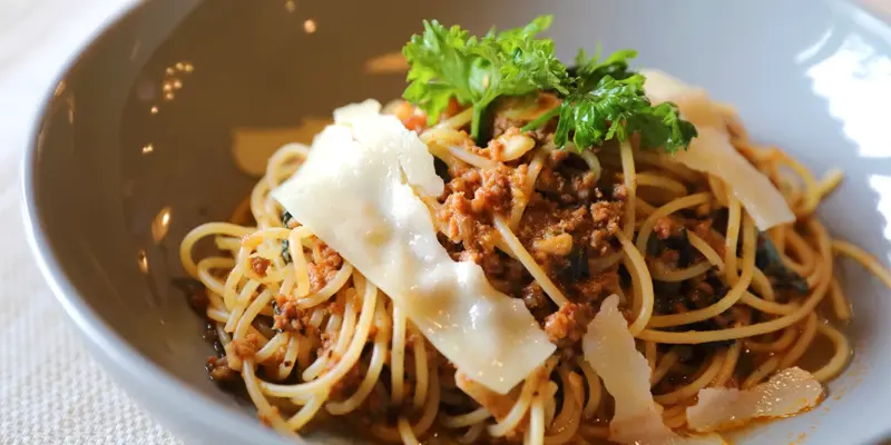 Delicious spaghetti with rich Bolognese sauce, topped with Parmesan cheese and fresh herbs. Perfect for a hearty Italian meal.
