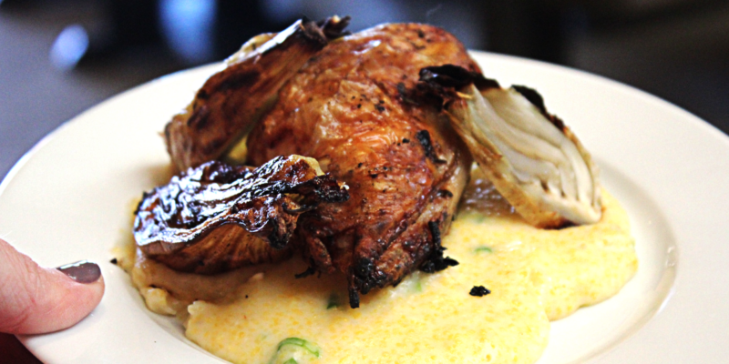 Delicious roasted chicken seasoned with herbs, served over creamy fennel and Parmesan polenta, perfect for a hearty meal.