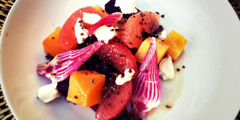 Colorful roasted beet salad with fresh fruit and cheese.