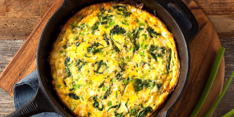 Bright spinach and chorizo frittata in a cast iron skillet.