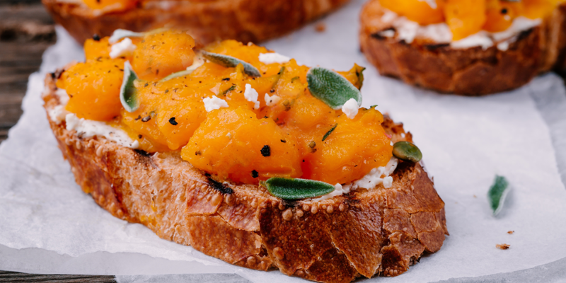 Delicious butternut squash bruschetta topped with herbs and cheese on toasted bread. Perfect appetizer for fall gatherings.
