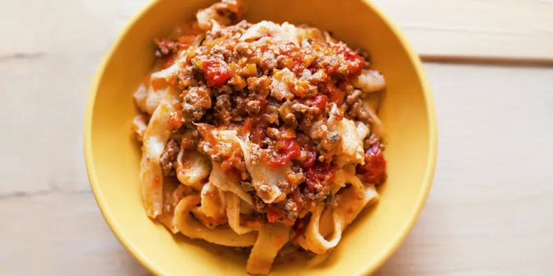 Delicious Sugo All’Amatriciana pasta dish in a yellow bowl.