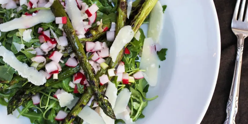 Fresh arugula and grilled asparagus salad with radishes and shaved cheese.