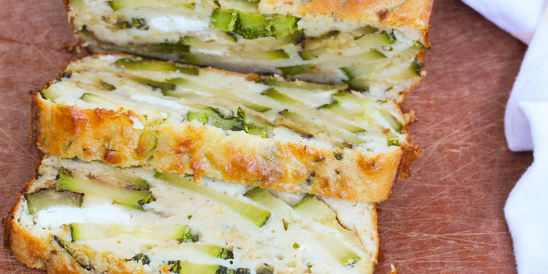 Delicious zucchini and goat cheese cake, sliced to reveal a creamy interior with fresh green zucchini pieces.