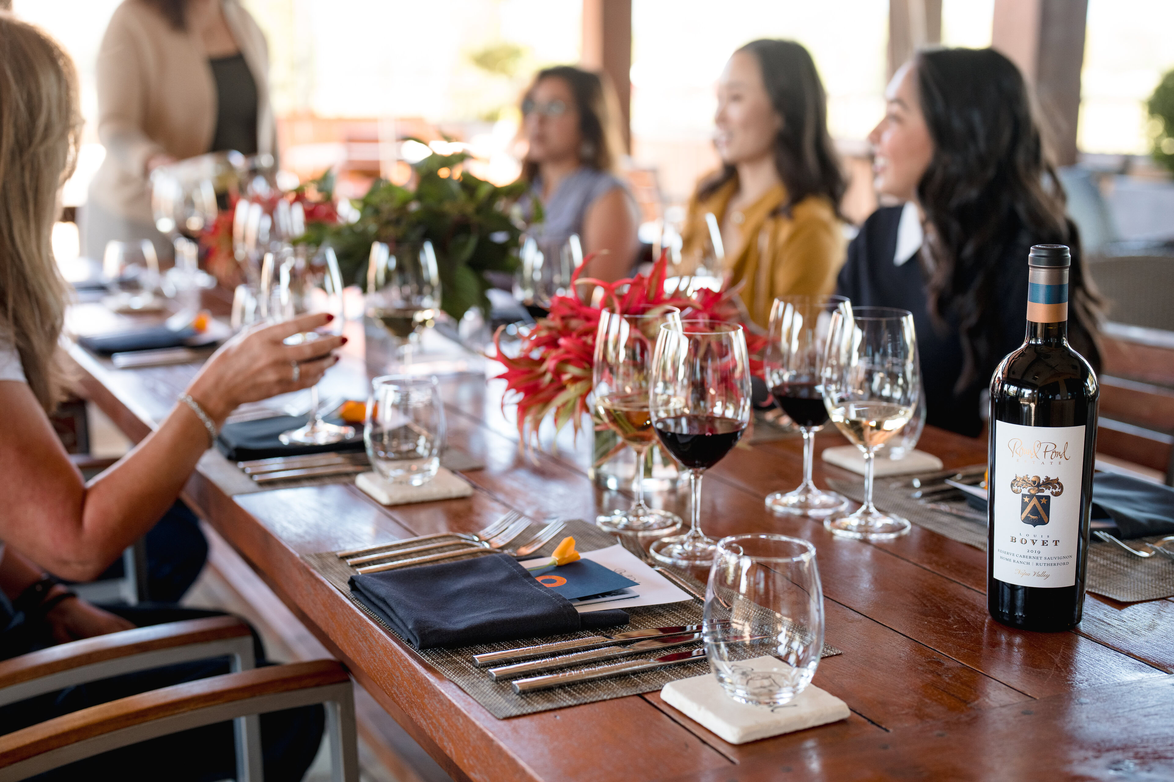 A group of women sit on the Round Pond Terrace enjoying wines